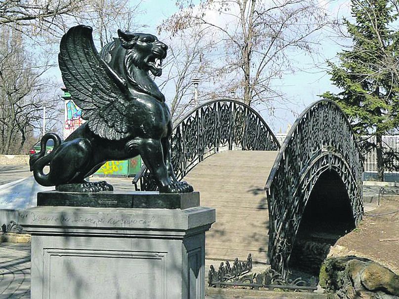 Грифон у скверику "Стара Одеса". На задньому плані - місток Кохання. Тут часто фотографуються весілля